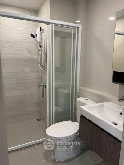Modern bathroom with glass shower enclosure and sleek fixtures