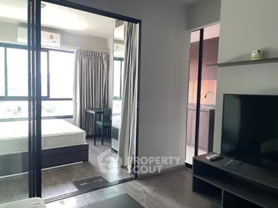 Modern apartment interior with bedroom and living area, featuring large windows and sleek furnishings.