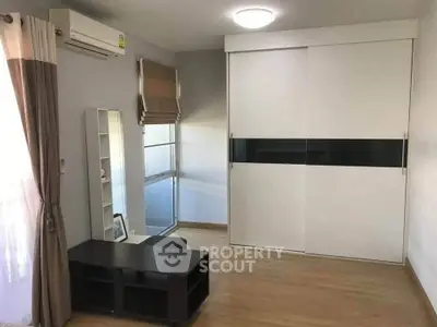 Spacious bedroom with modern sliding wardrobe and natural light.