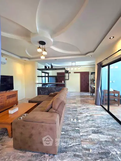 Spacious living room with elegant ceiling design and marble flooring