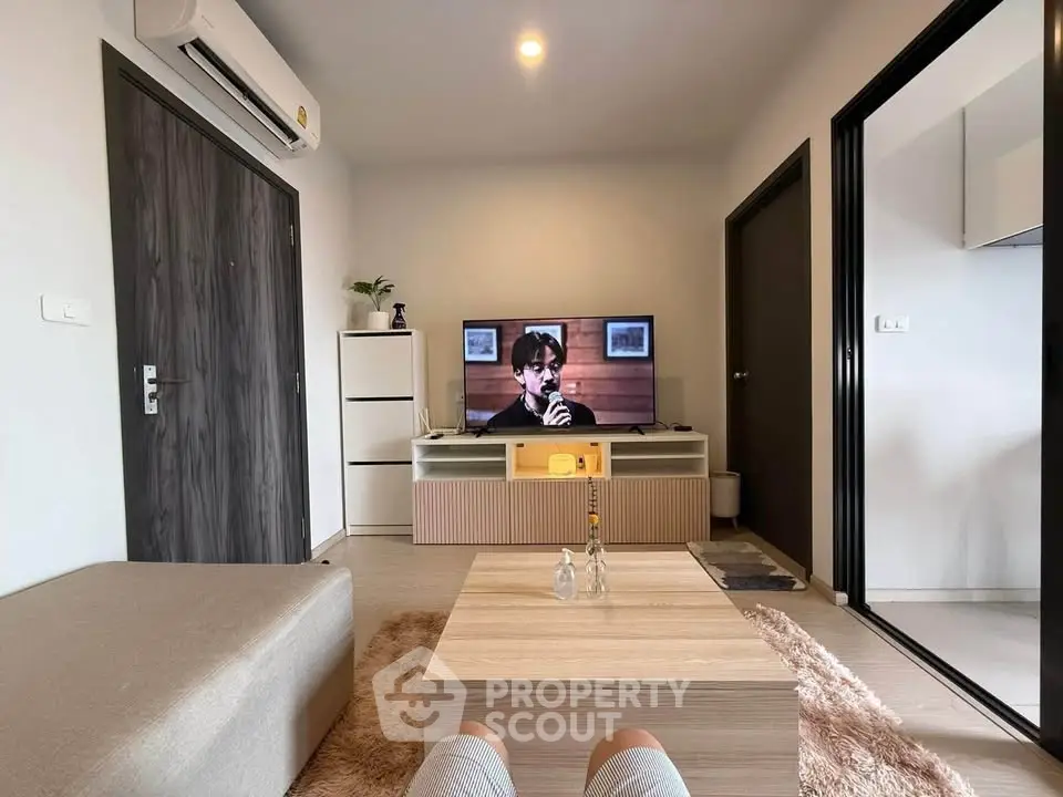 Modern living room with sleek furniture and TV, perfect for relaxation and entertainment.