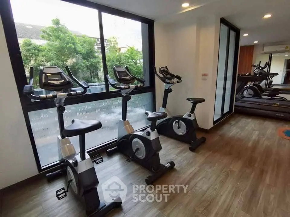 Modern gym with exercise bikes and treadmills in a bright, spacious room.