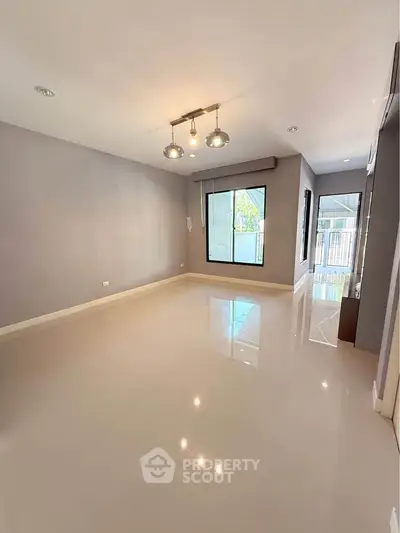 Spacious empty living room with modern lighting and large windows