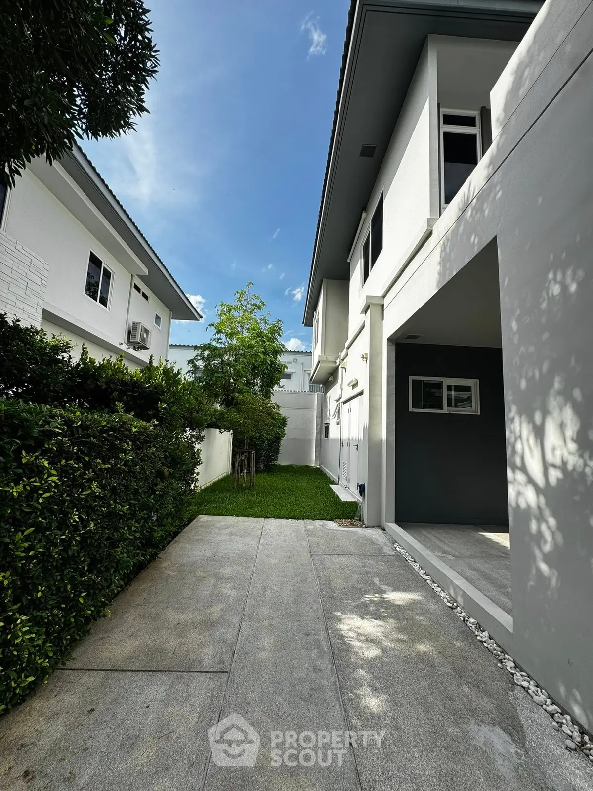 Modern two-story house with driveway and lush greenery, perfect for family living.