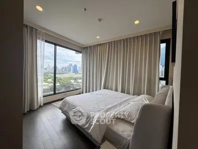 Spacious bedroom with city view and large windows in modern apartment