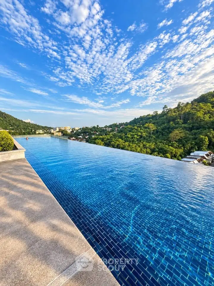 Stunning infinity pool with breathtaking panoramic views of lush green hills and blue skies.