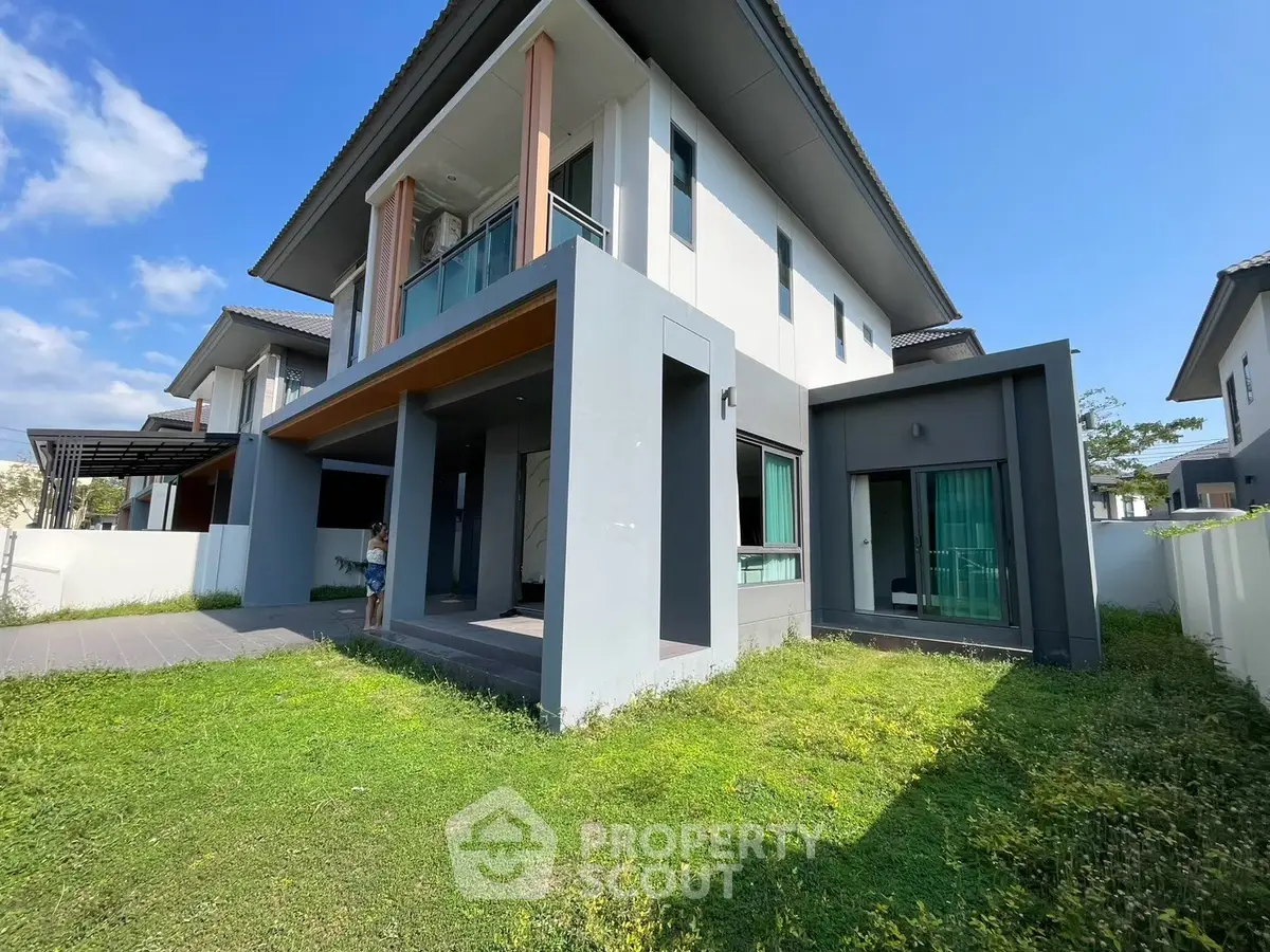 Modern two-story house with spacious garden and stylish balcony
