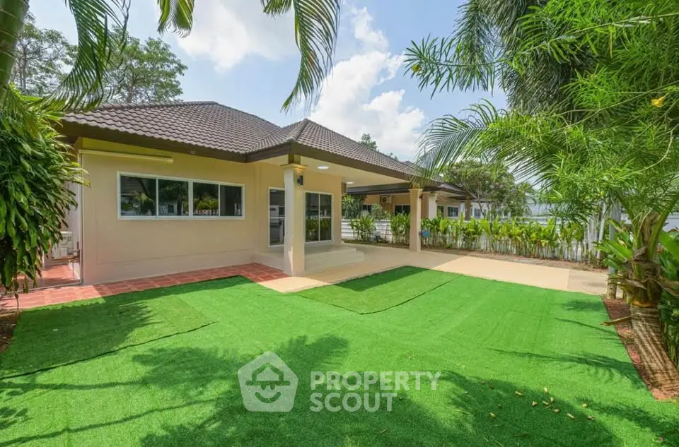 Charming single-story home with lush garden and spacious patio, perfect for outdoor living.