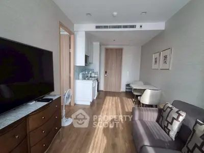 Modern living room with kitchenette and stylish decor in a cozy apartment.