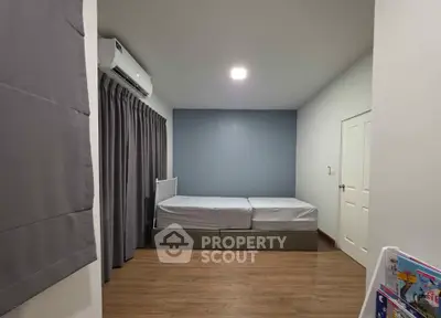 Spacious bedroom with twin beds and modern decor in a cozy apartment.