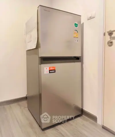 Modern stainless steel refrigerator in a sleek kitchen corner, perfect for contemporary apartments.