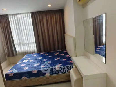 Cozy bedroom with large window and modern furnishings in a stylish apartment.