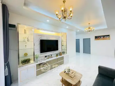 Luxurious living room with elegant chandeliers and modern decor, featuring a sleek entertainment center and cozy seating.