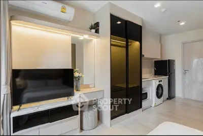Modern studio apartment with sleek interior, featuring a compact kitchen and stylish living area.