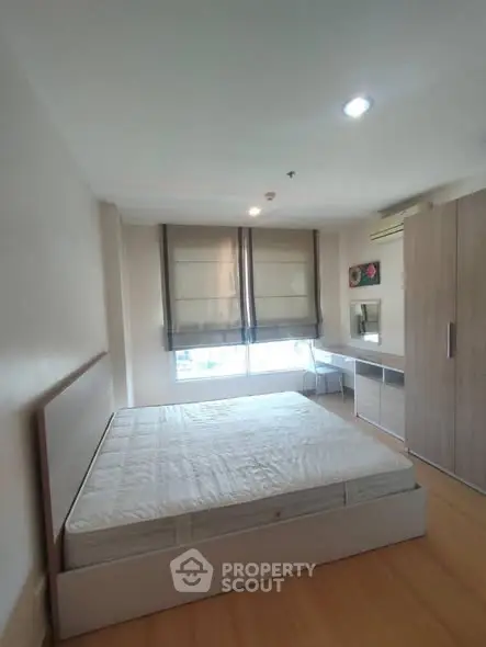 Spacious bedroom with large window and modern furnishings