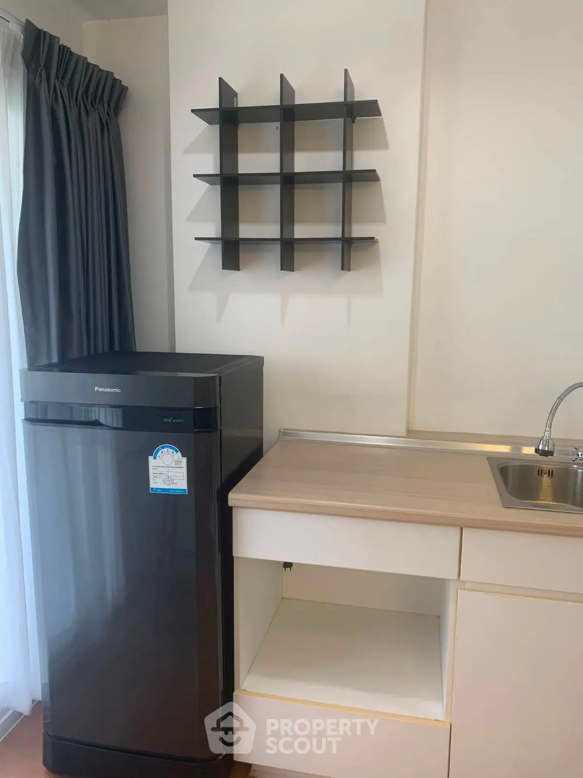 Modern kitchen corner with sleek fridge and minimalist shelving
