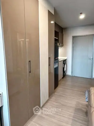 Modern apartment interior with sleek kitchen and ample storage space.