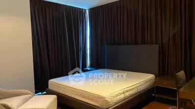 Spacious bedroom with elegant dark curtains and modern furniture