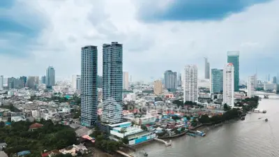 Stunning aerial view of modern high-rise buildings along a river in a bustling cityscape.