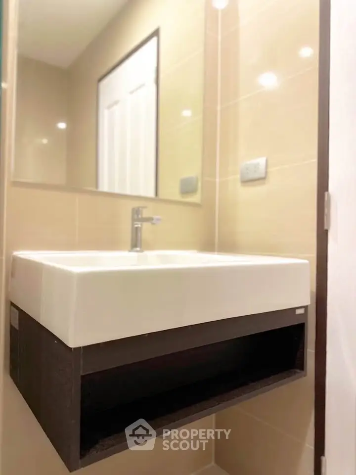 Modern bathroom with sleek sink and mirror in a stylish real estate property.