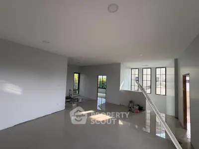 Spacious modern living room with large windows and natural light