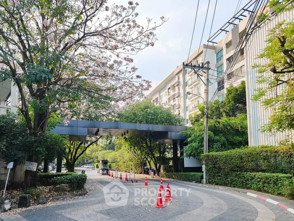 Charming residential building entrance with lush greenery and modern architecture.