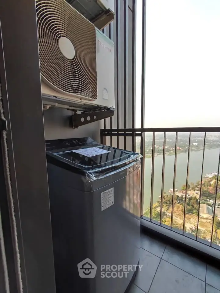 High-rise balcony with washing machine and scenic river view, perfect for urban living.
