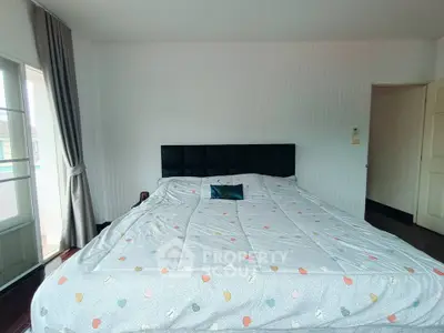 Spacious bedroom with large bed and natural light from window