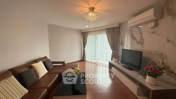 Elegant living room with modern decor, featuring a cozy sofa, stylish chandelier, and large window with city view.