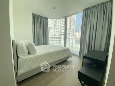 Modern bedroom with large windows and city view, featuring a cozy bed and sleek furniture.
