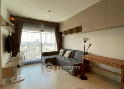 Modern living room with city view, featuring sleek furniture and ample natural light.