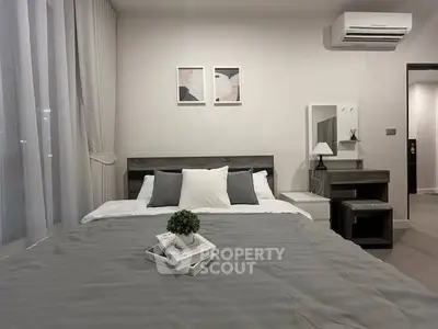 Modern bedroom with stylish decor and air conditioning, featuring a cozy bed and elegant furnishings.
