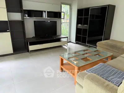 Spacious living room with modern entertainment center and cozy seating area.