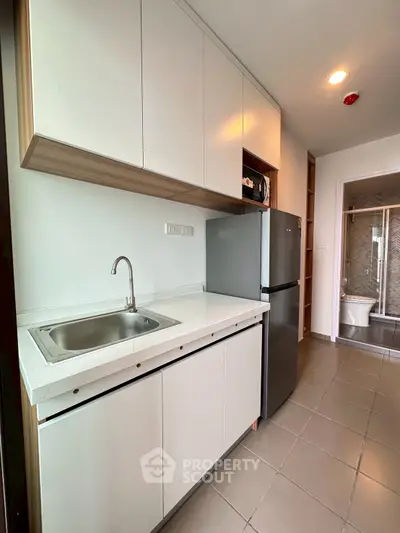 Modern kitchen with sleek cabinetry and stainless steel appliances in a contemporary apartment.