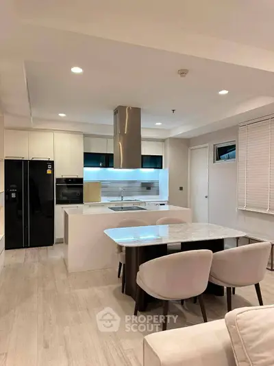 Modern kitchen with open layout and sleek dining area in a stylish apartment.