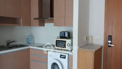 Modern kitchen with integrated washing machine and microwave in compact layout.