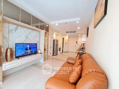 Modern living room with leather sofa, marble TV wall, and sleek design in a stylish apartment.