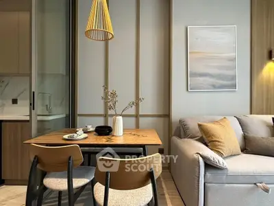 Modern living room with stylish dining area and cozy sofa, featuring elegant decor and warm lighting.