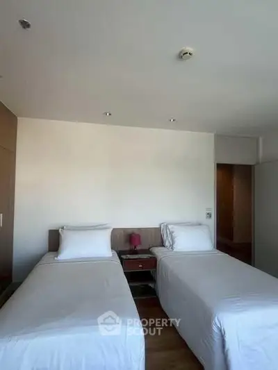 Cozy twin bedroom with modern decor and ample natural light