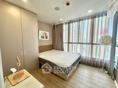 Modern bedroom with large windows and stylish decor in a high-rise apartment.