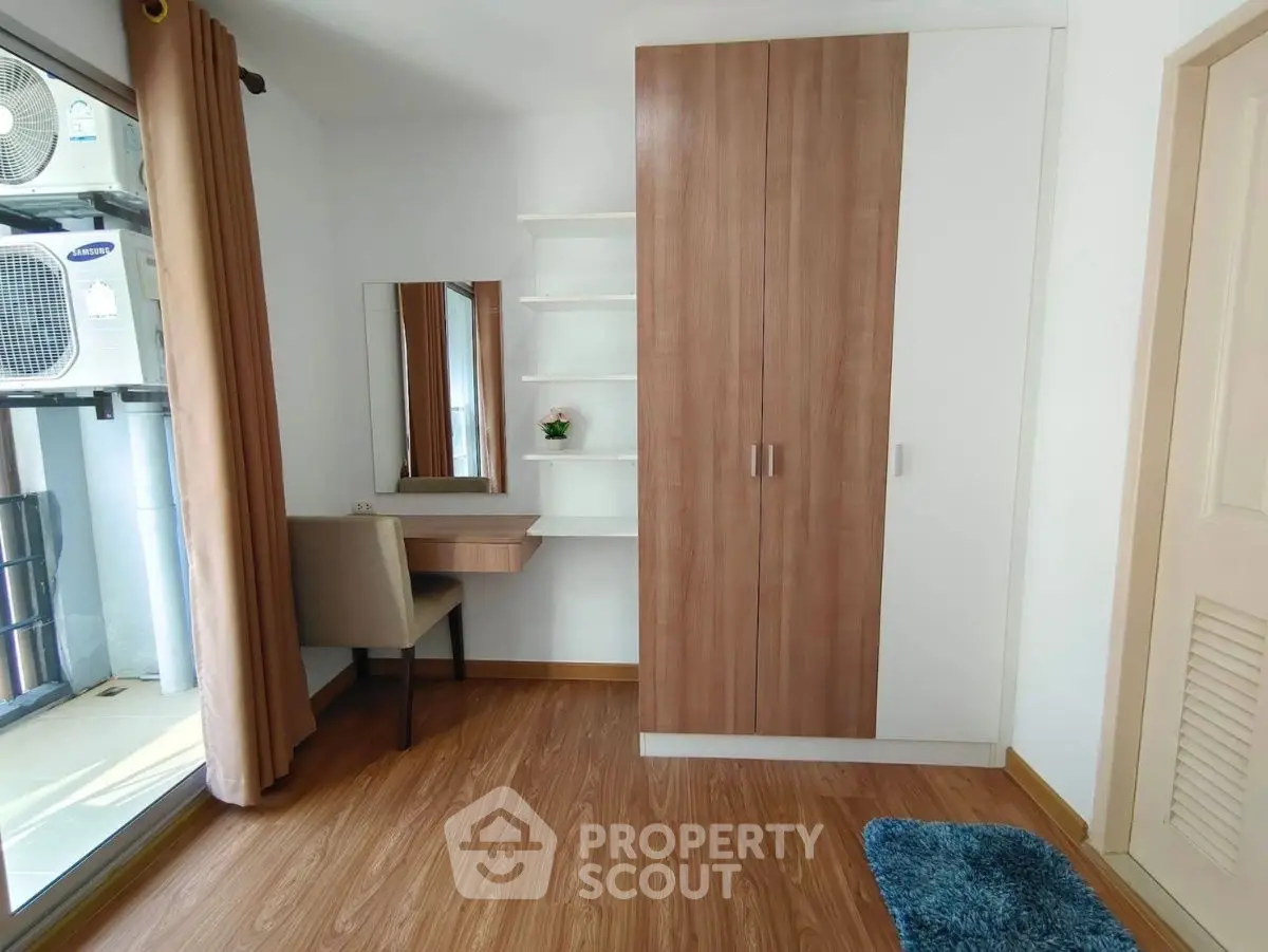 Cozy bedroom with wooden flooring and built-in wardrobe, perfect for modern living.