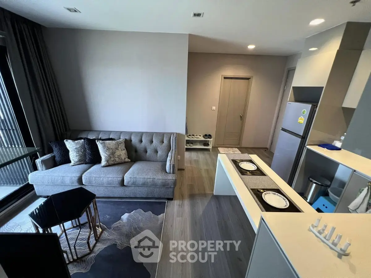 Modern living room with stylish sofa and open kitchen layout in a contemporary apartment.