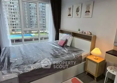 Modern bedroom with large window and stylish decor overlooking pool view.