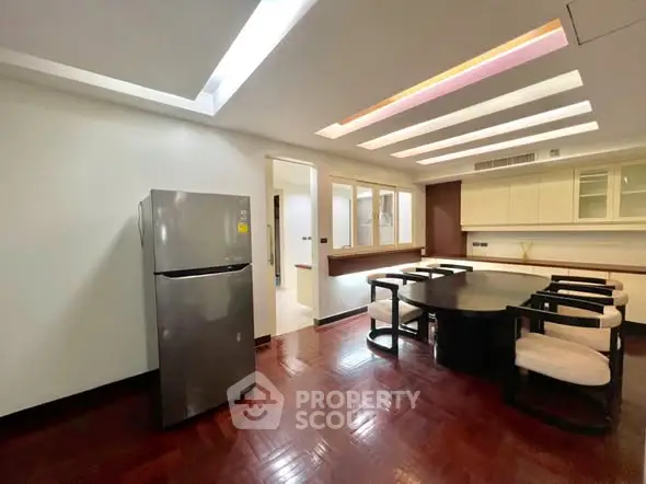 Spacious dining area with modern lighting and sleek refrigerator