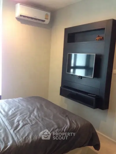 Modern bedroom with wall-mounted TV and air conditioning unit