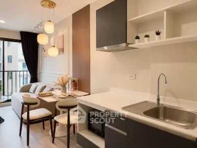 Modern open-layout kitchen and living area with stylish decor and natural light.