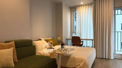 Cozy bedroom with modern decor and natural light, featuring a comfortable bed and stylish seating area.