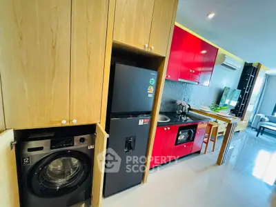 Modern kitchen with vibrant red cabinets, built-in appliances, and sleek design in a contemporary apartment.