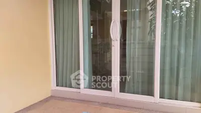 Spacious balcony with sliding glass doors and elegant curtains, perfect for relaxation and outdoor enjoyment.