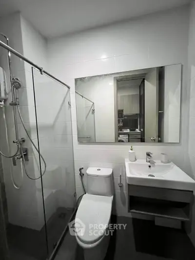 Modern bathroom with glass shower and sleek fixtures in a contemporary apartment.